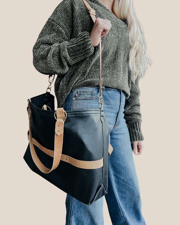 model is wearing a leather laptop tote bag, black leather handbag, lots of interior function, designer details, handmade in USA, sustainably sourced leather