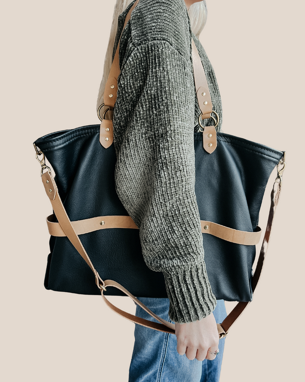 model is wearing a leather laptop tote bag, black leather handbag, lots of interior function, designer details, handmade in USA, sustainably sourced leather