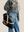 model is wearing a leather laptop tote bag, black leather handbag, lots of interior function, designer details, handmade in USA, sustainably sourced leather