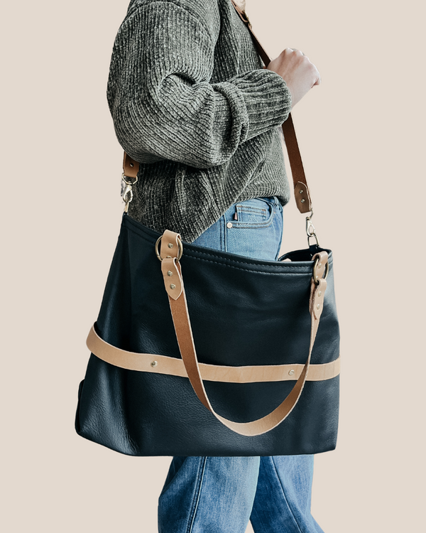 model is wearing a leather laptop tote bag, black leather handbag, lots of interior function, designer details, handmade in USA, sustainably sourced leather