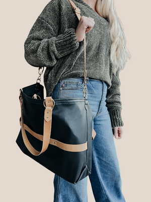 model is wearing a leather laptop tote bag, black leather handbag, lots of interior function, designer details, handmade in USA, sustainably sourced leather
